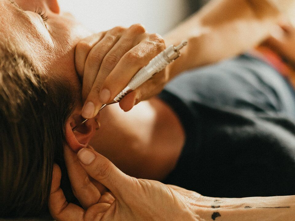 Séance de réflexologie auriculaire : stimulation d’un point du pavillon de l’oreille
